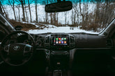 Car interior with a focus on the dashboard and steering wheel, showing a snowy landscape outside.