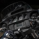 Close-up of a motorcycle dashboard with controls and display.