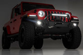Red Jeep Wrangler with off-road lights on a dark background