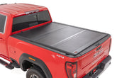 Red GMC truck with a black tonneau cover on a white background