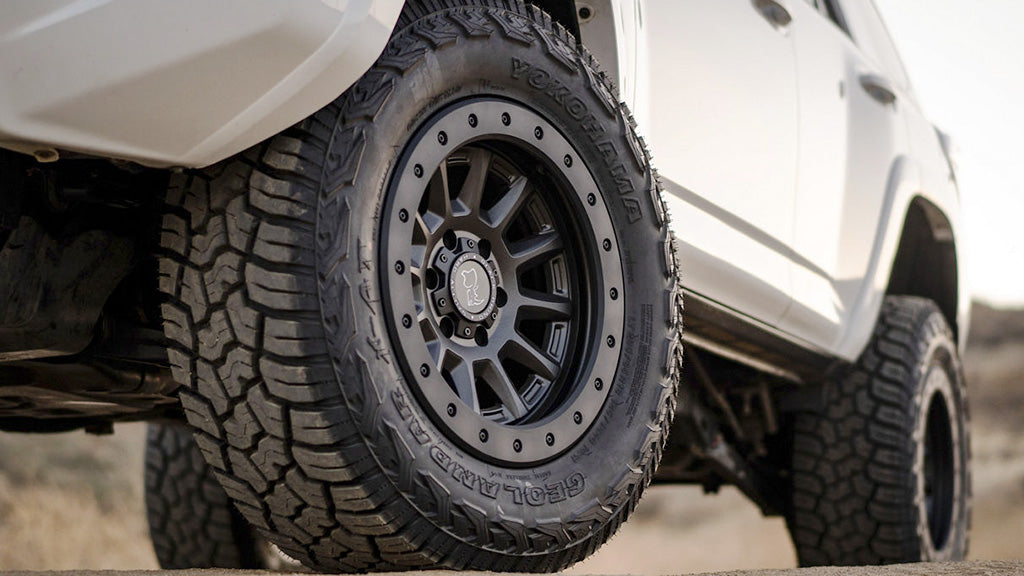 Close-up of a vehicle tire with a detailed tread pattern on a blurred background