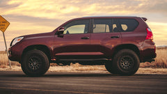 Maroon SUV on a road with custom wheels