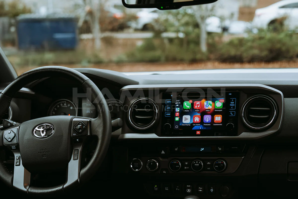 Car interior with dashboard and steering wheel, showing a smartphone app interface.