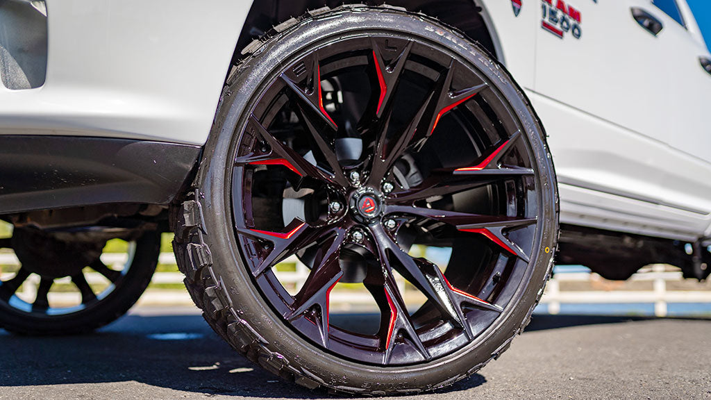 Close-up of a car wheel with black and red design, blurred background