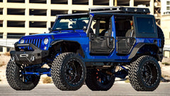 A blue off-road Jeep with 22-inch TIS 544BM parked on a street.