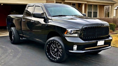 A black pickup truck With TIS 22" 544BM Custom Wheels parked on the street.
