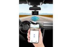 Car dashboard with a rearview camera and smartphone displaying app interface.
