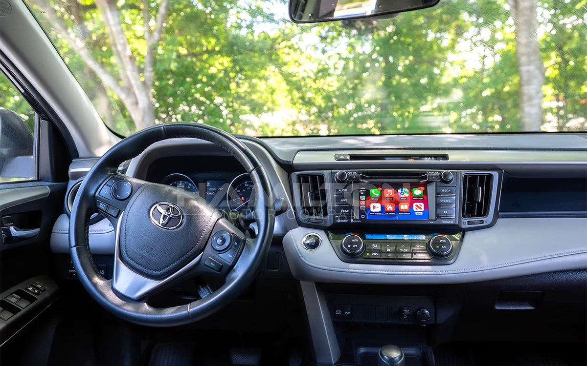 Car interior with steering wheel and dashboard showing a touchscreen display.