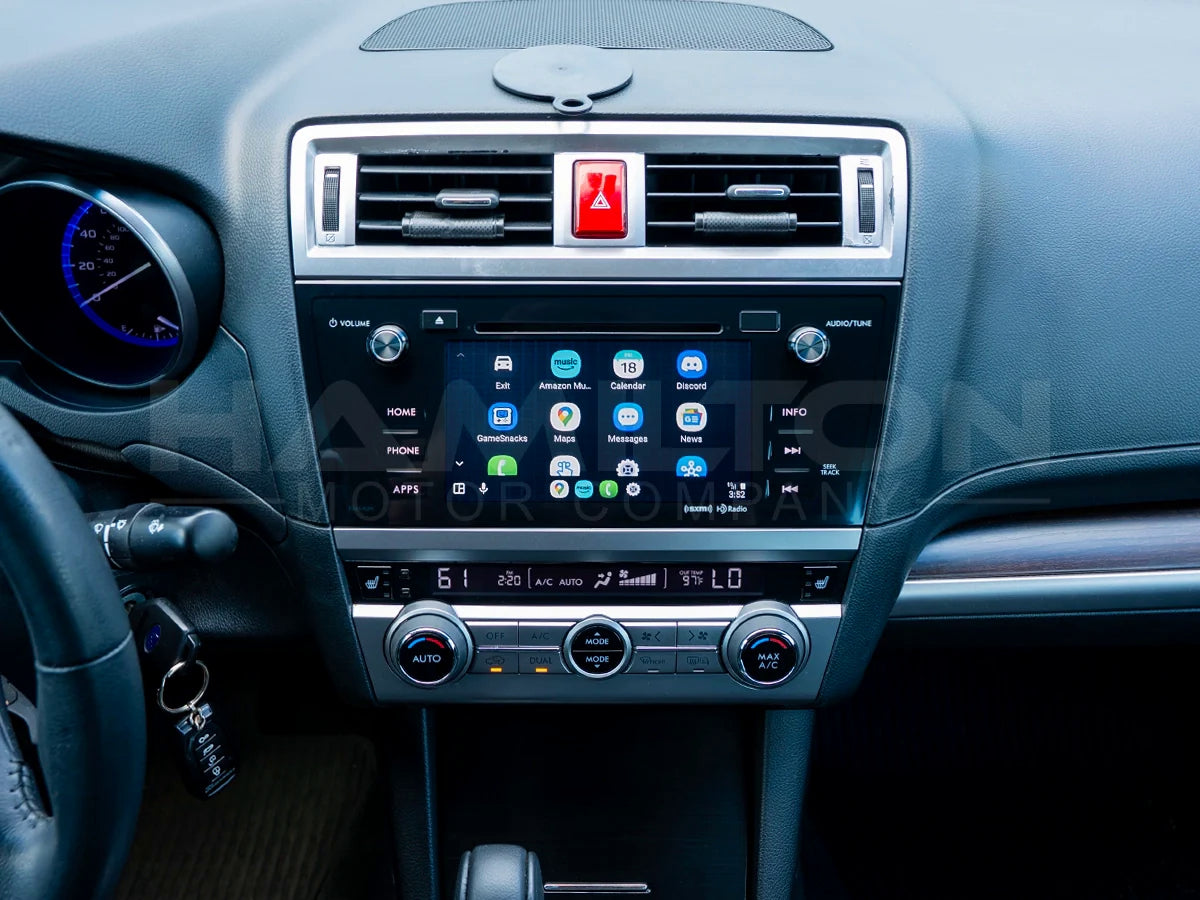 Car dashboard with digital display and air vent, featuring a brand logo.
