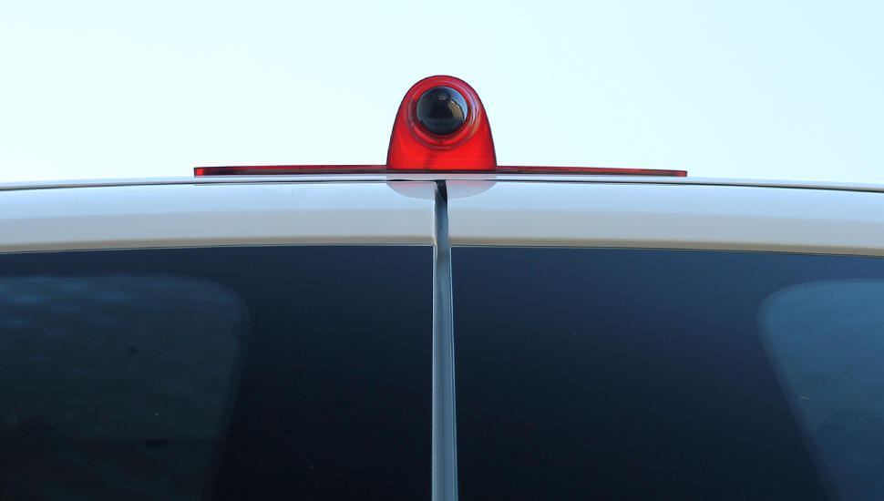 Red car antenna on a vehicle with a clear sky background