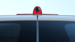 Red car antenna on a vehicle with a clear sky background