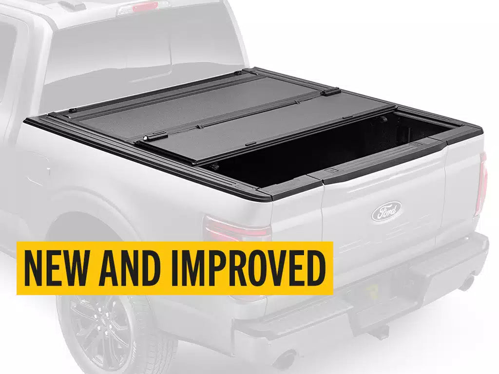 Black tonneau cover on a white truck with 'NEW AND IMPROVED' text overlay.