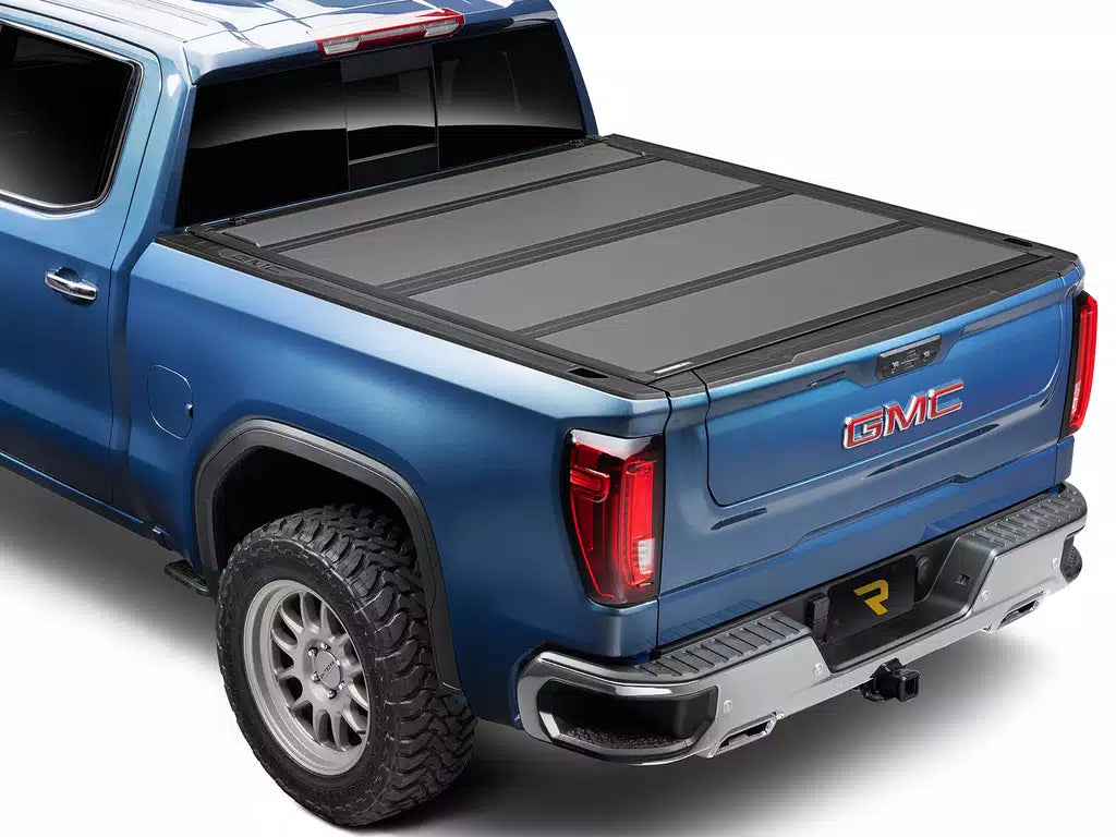 Blue GMC truck with a tonneau cover on a white background