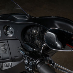 Close-up of a motorcycle handlebar with controls and mirror on a dark background