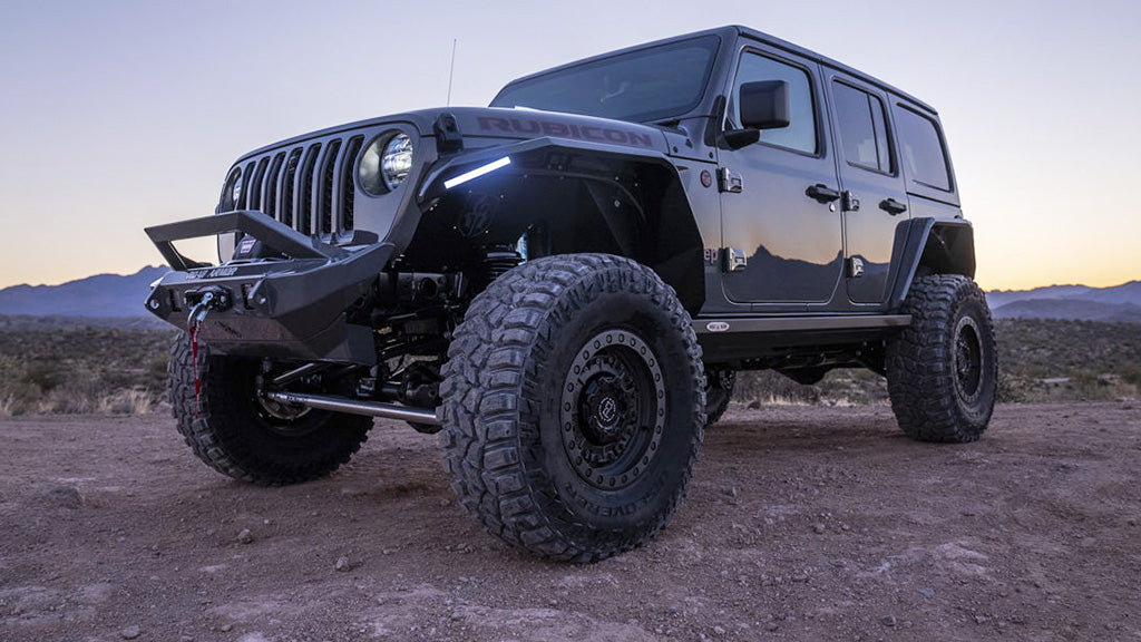 Black off-road vehicle on a dirt road with mountains in the background