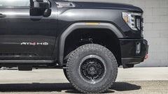 Black truck with 'AT4 HD' branding on a gray background