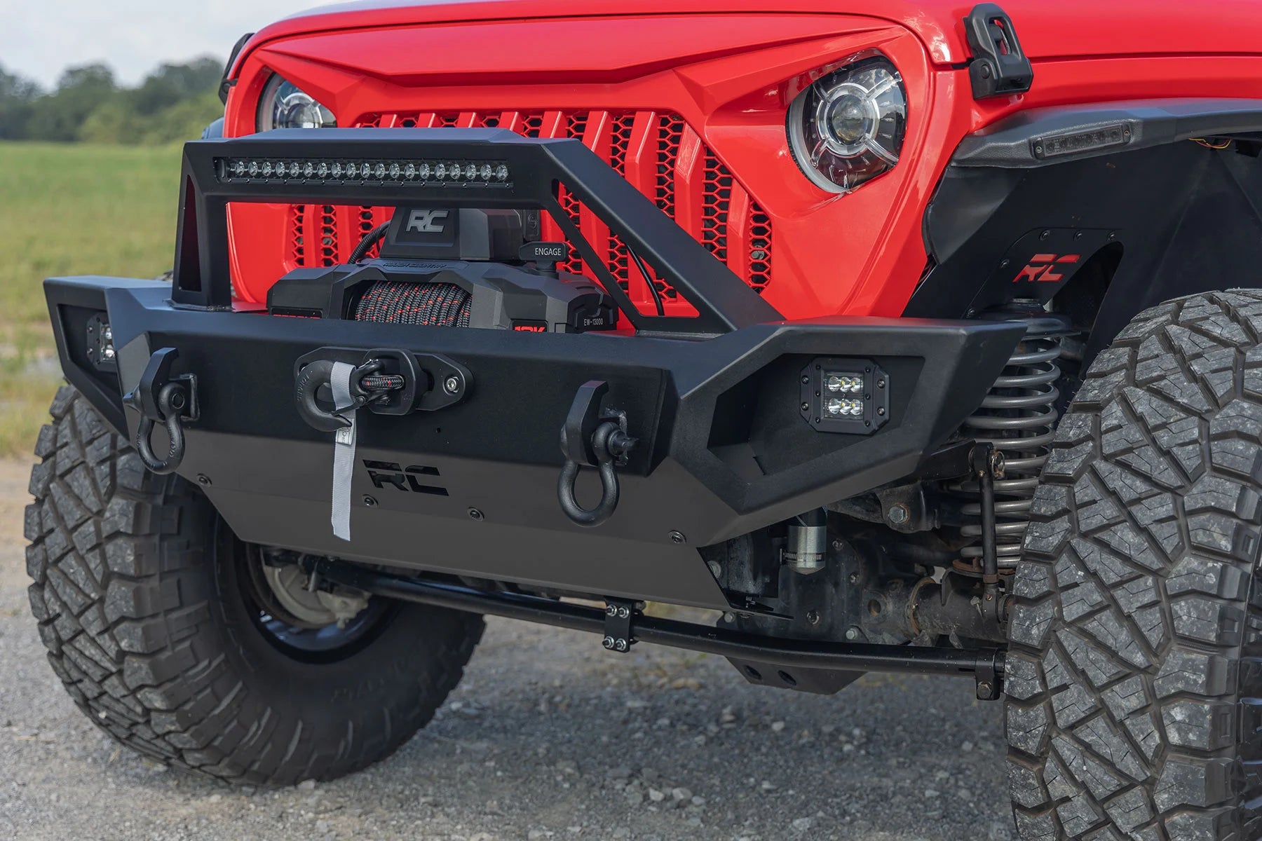 Red Jeep with a black front bumper on a road