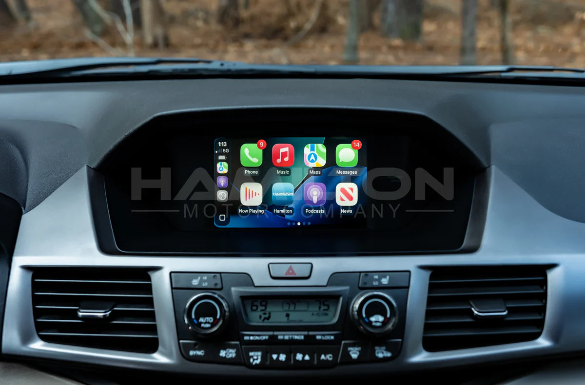 Car dashboard with a touchscreen display showing app icons, branded 'Hamilton Motor Company.'