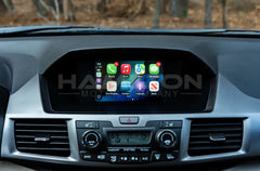 Car dashboard with a touchscreen display showing app icons, branded 'Hamilton Motor Company.'