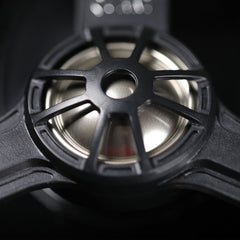 Close-up of a black speaker cone with metallic interior on a dark background