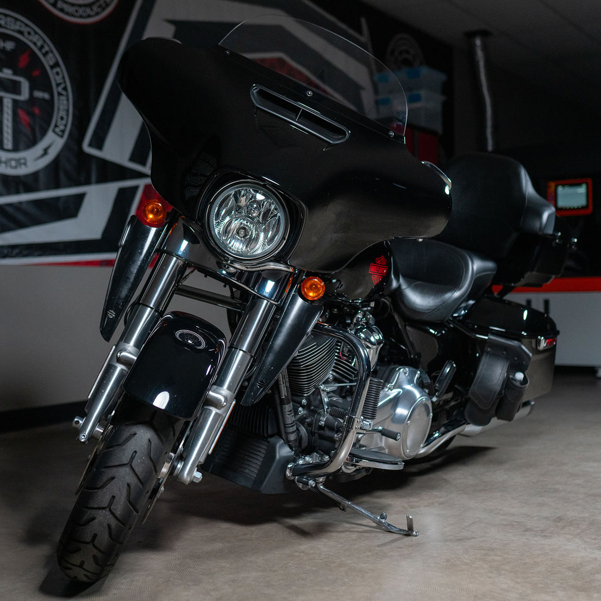 Black motorcycle parked indoors with a blurred background