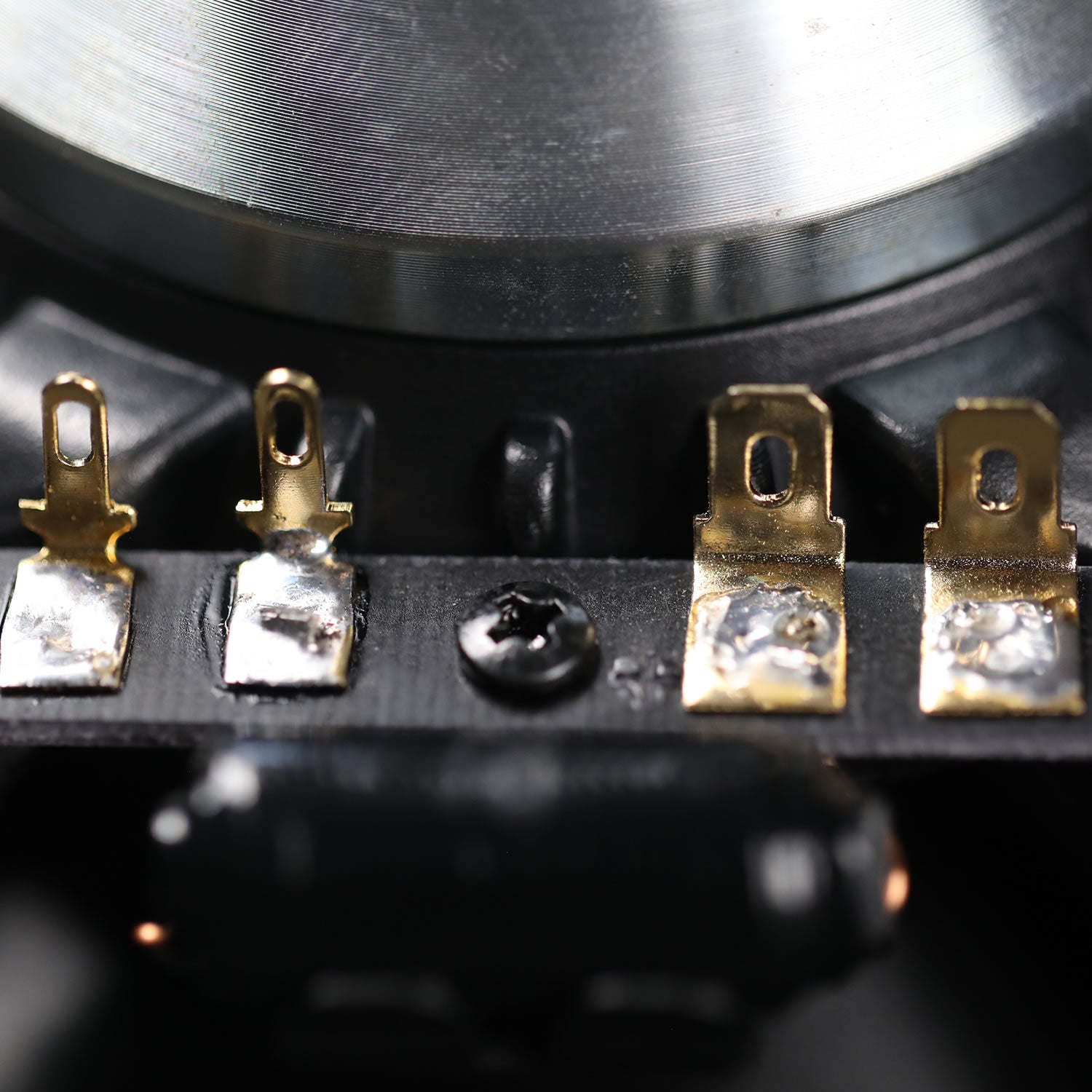 Close-up of electronic components with gold and silver contacts on a black background