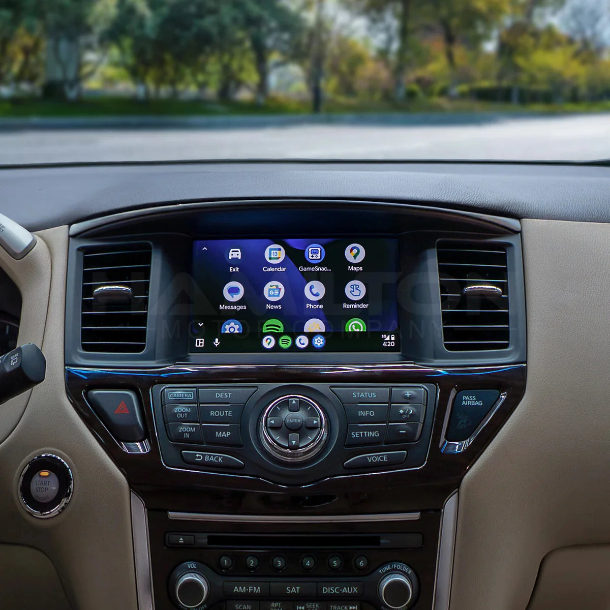 Car dashboard with a touchscreen display and control buttons, outdoors.