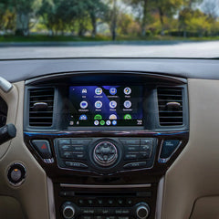 Car dashboard with a touchscreen display and control buttons, outdoors.