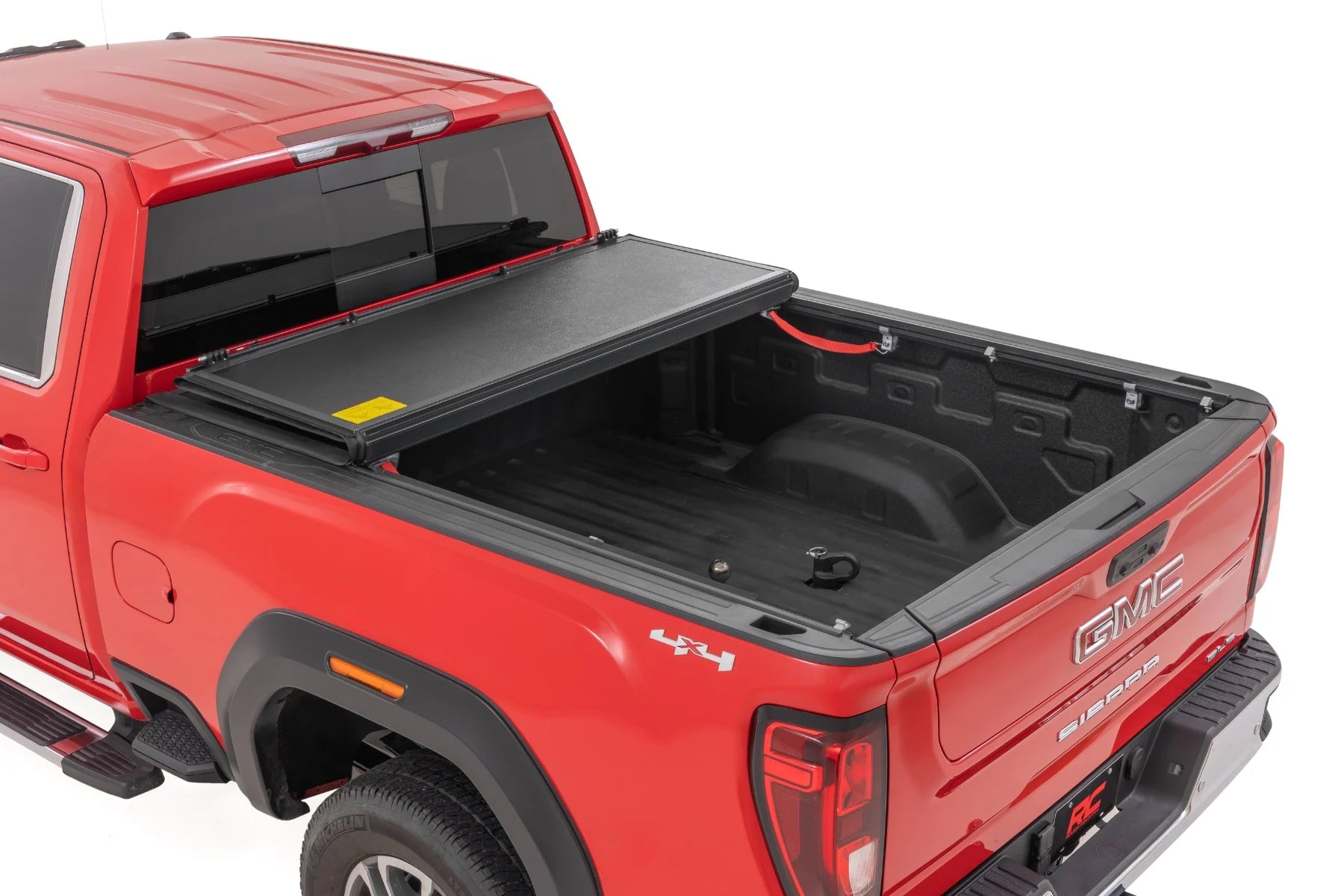 Red GMC truck with a black tonneau cover on a white background