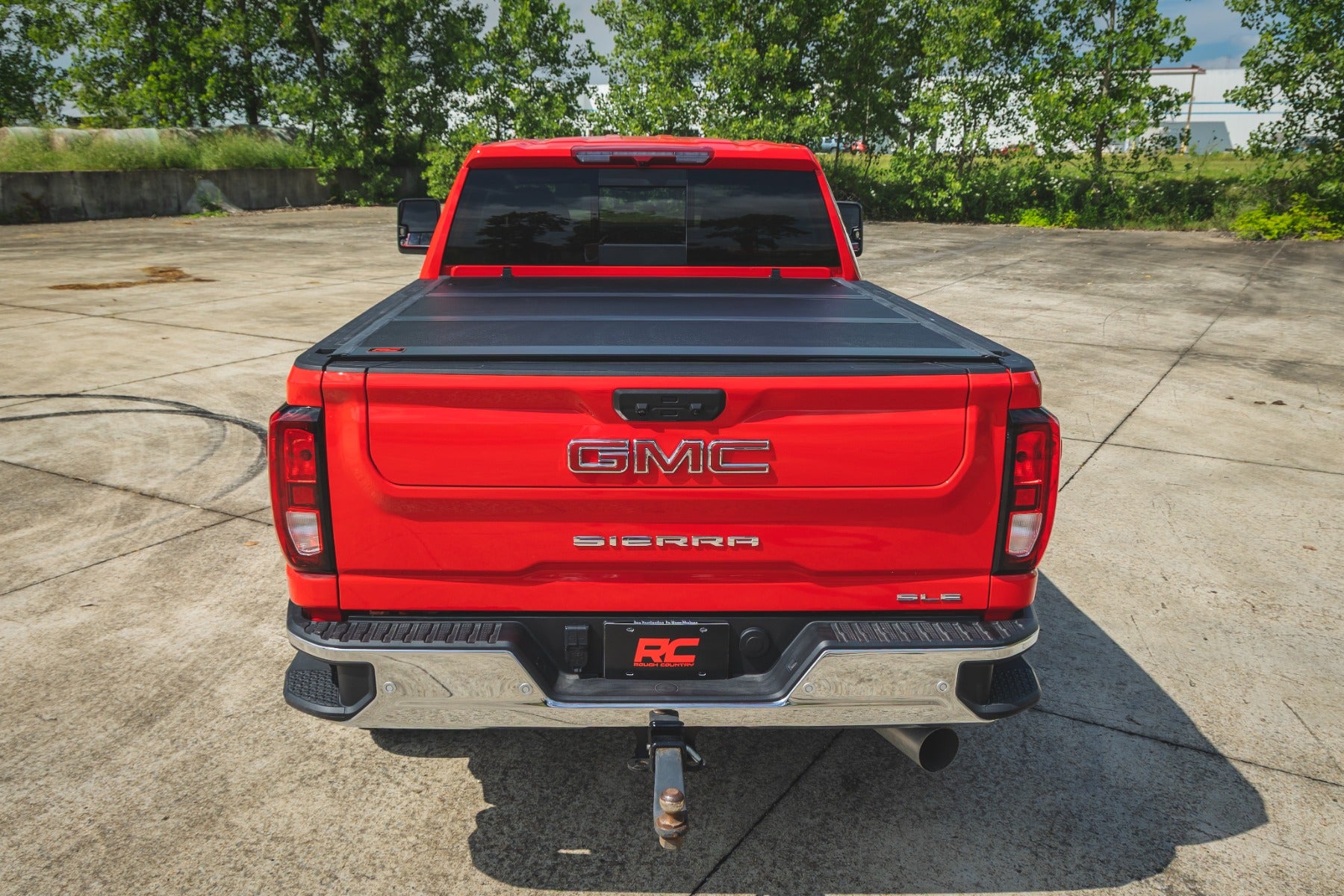 Red GMC Sierra truck shown from the rear with a tonneau cover