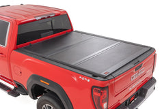 Red GMC truck with a black tonneau cover on a white background