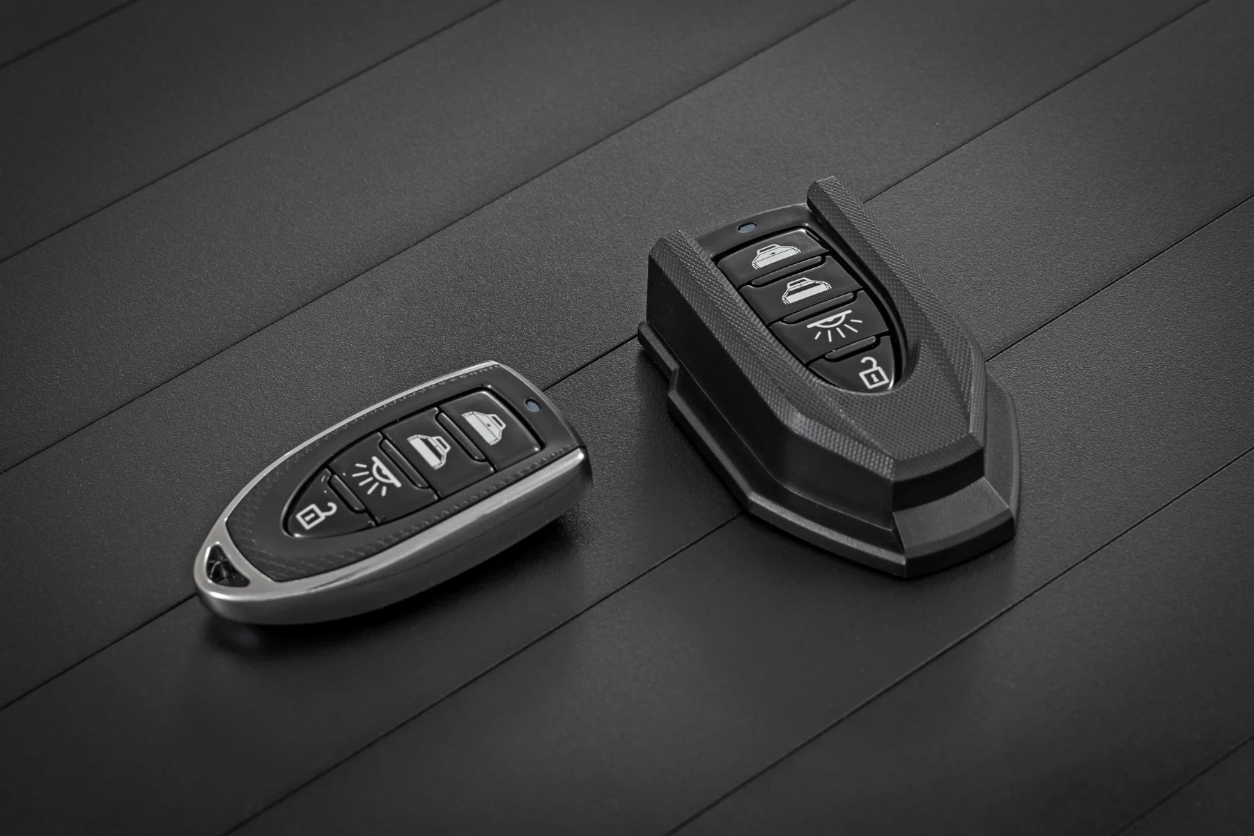 Two car key fobs on a dark wooden surface