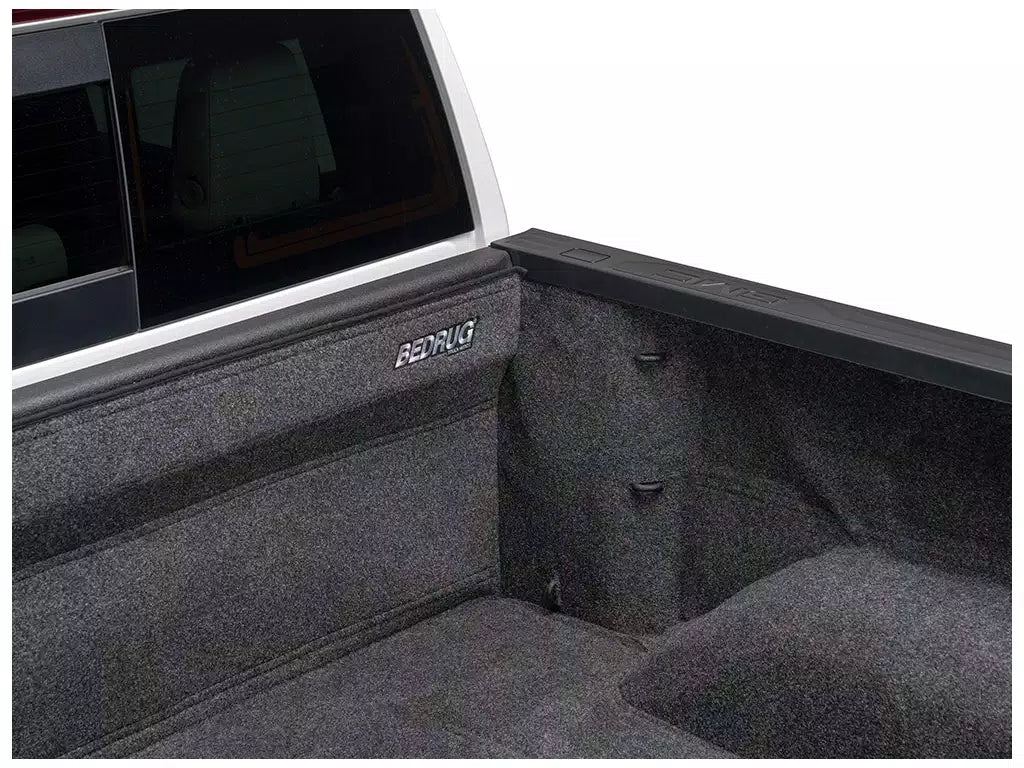 Close-up of a truck bed with a textured surface and 'Bedrug' branding.