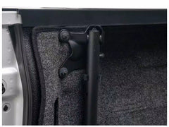 Close-up of a car door panel with a black support bar and carpet lining.