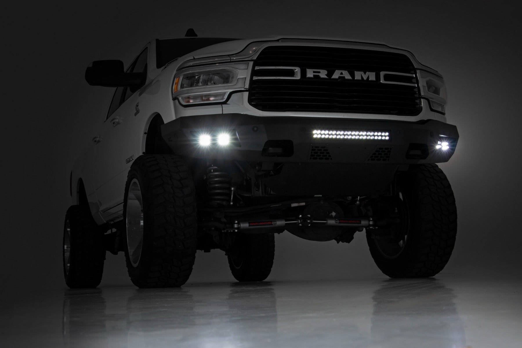 Front view of a RAM truck with illuminated headlights on a dark background