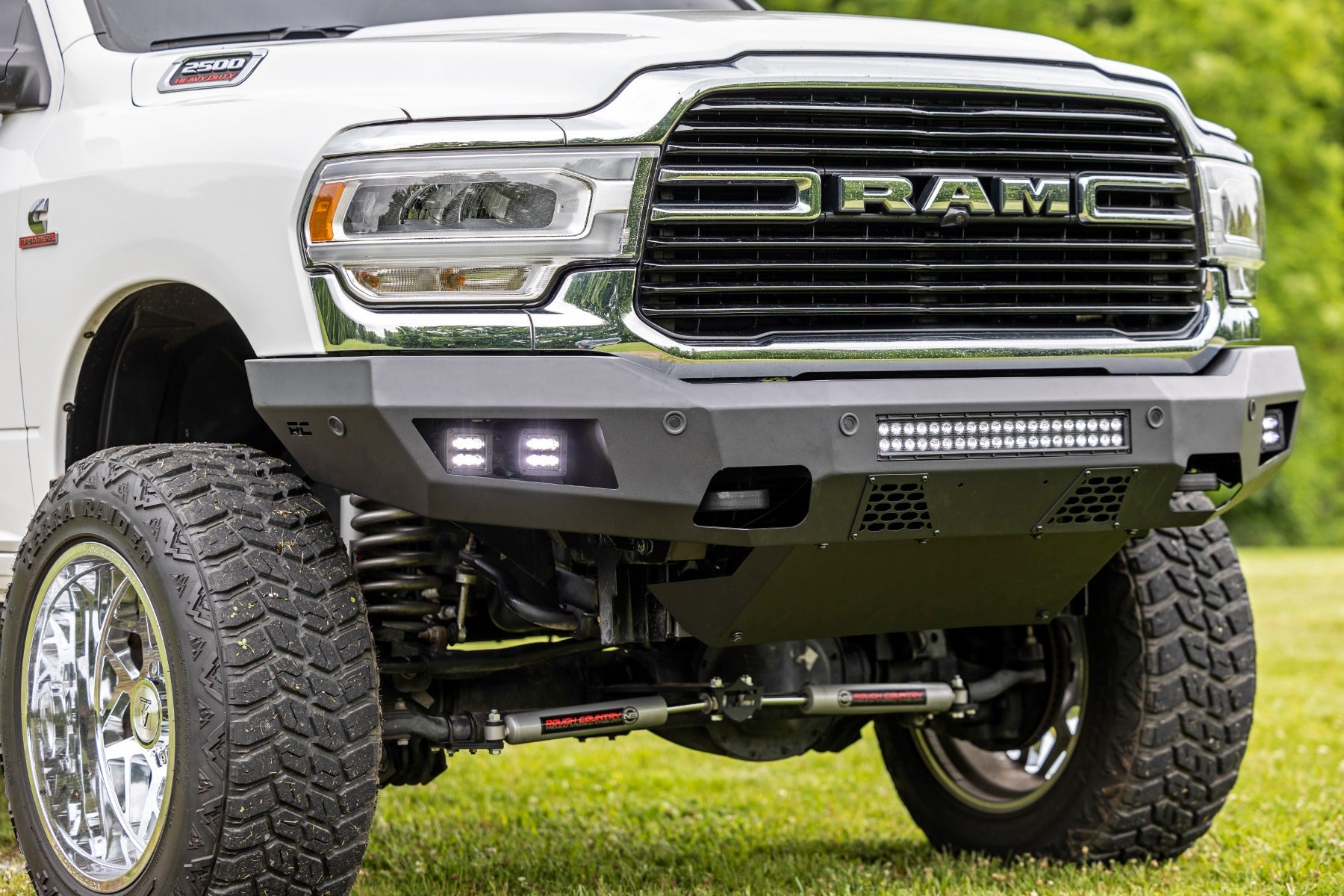 White Ram truck with off-road modifications on a grassy background