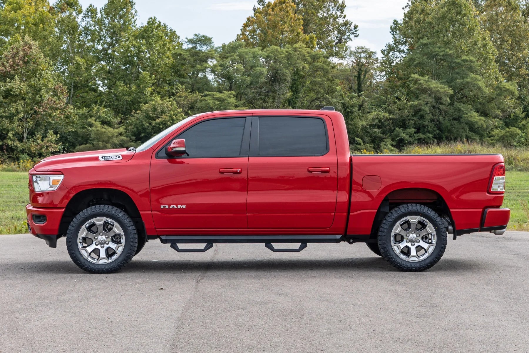 Red Ram truck parked on a paved road with trees in the background