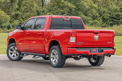 Red pickup truck on a road with trees in the background