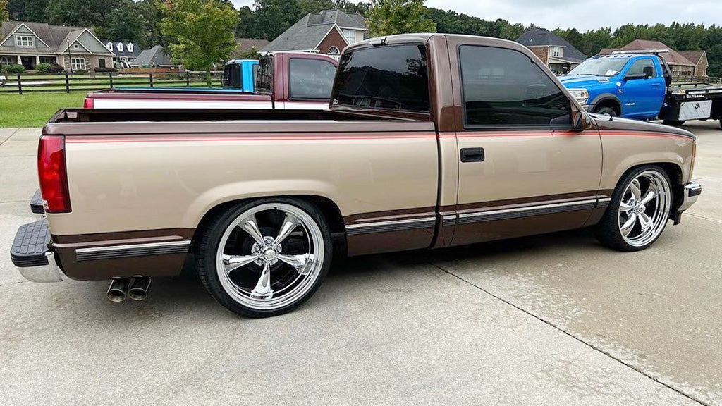 Beige pickup truck with chrome wheels on a driveway