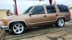 Bronze SUV with chrome rims parked on a street